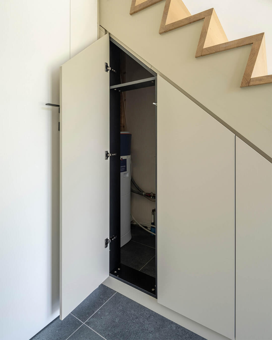 Custom staircase cabinet for enclosing utilities, in the color Turtle Grey