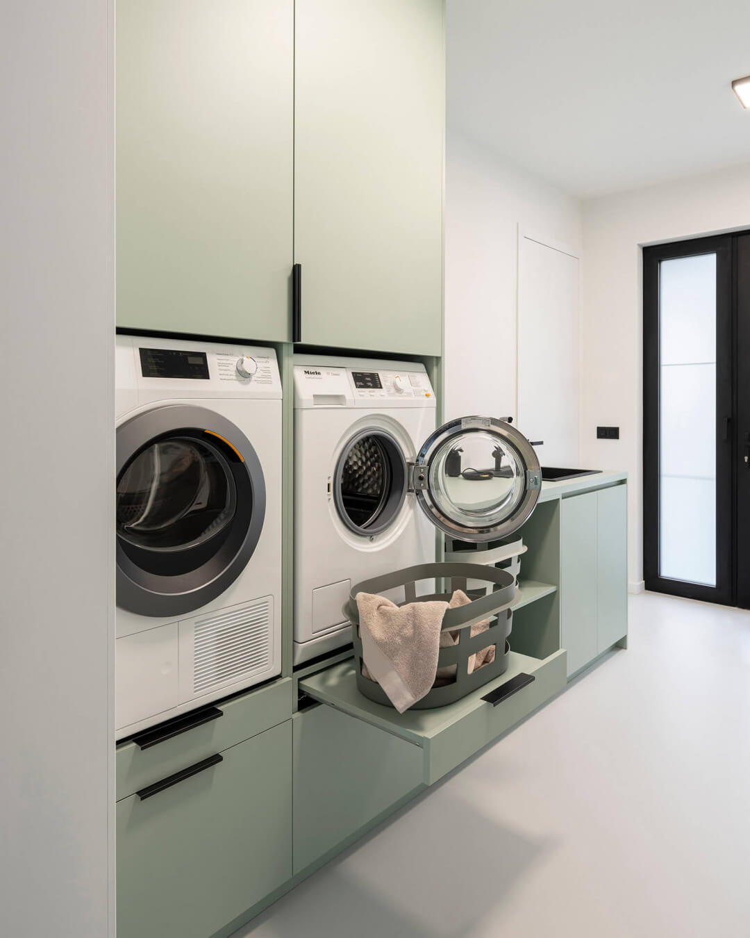 Custom-made laundry room with a custom laundry cabinet in the color Industrial Green