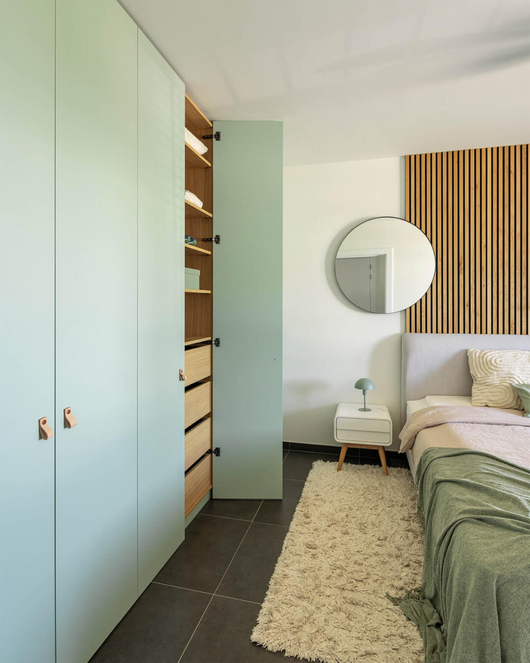 Bedroom with warm wood shades and soft green colors by Maatkasten Online