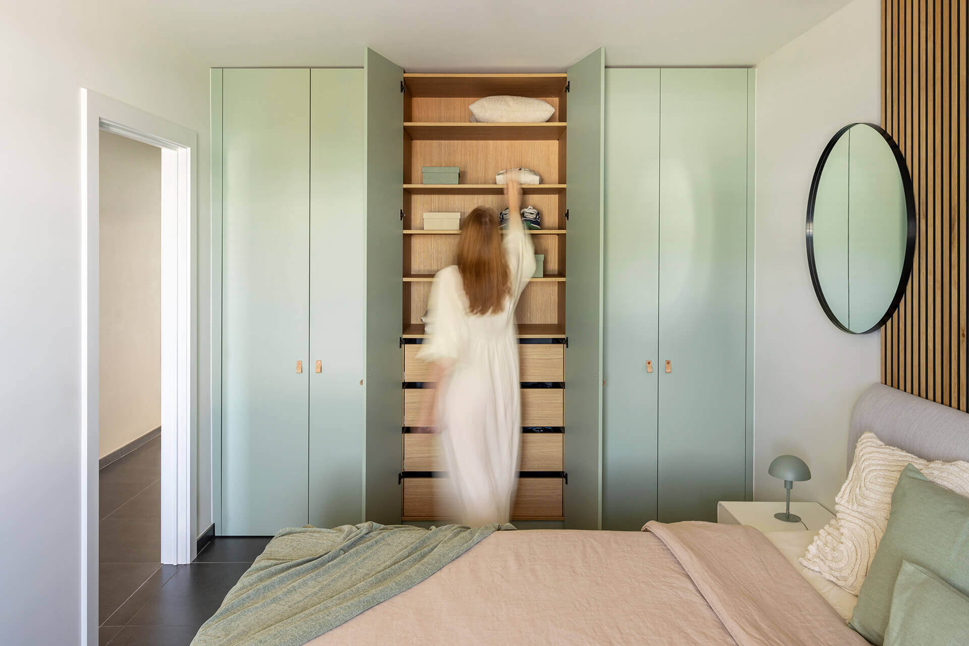 Bedroom with soft green tones and warm wood shades by Maatkasten Online