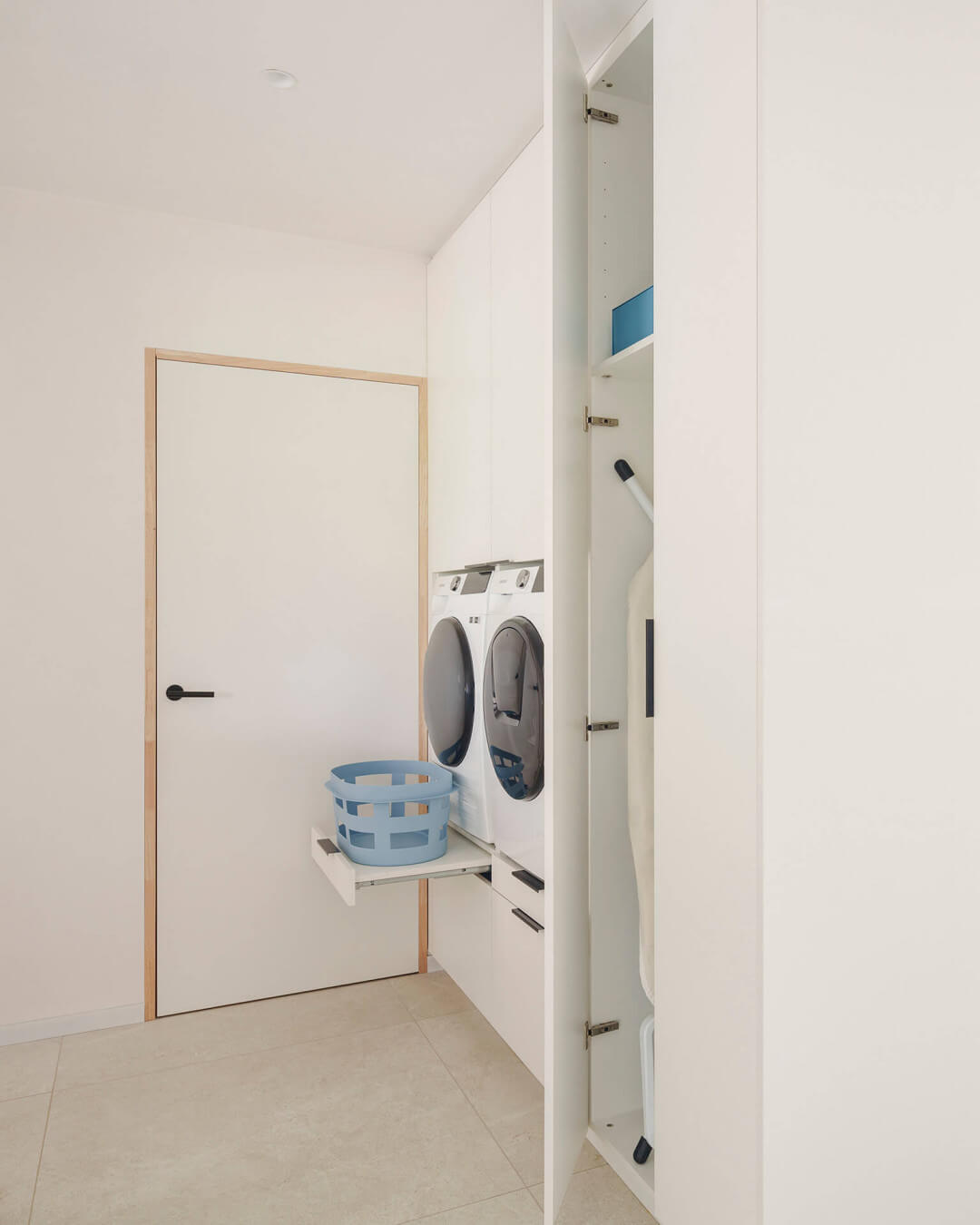 Built-in washing machines in a custom white laundry cabinet