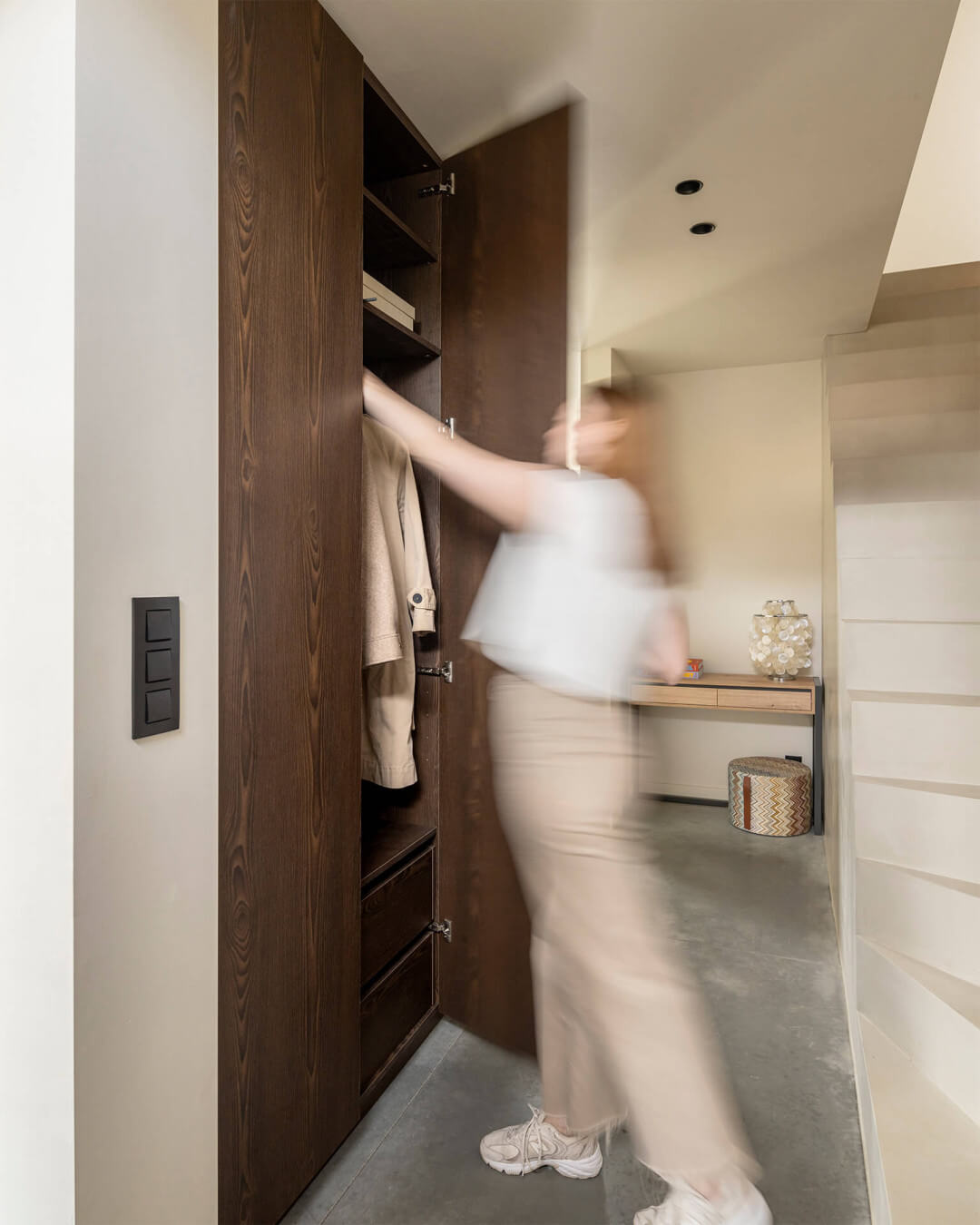 Built-in custom closet in the entrance hall in dark wood