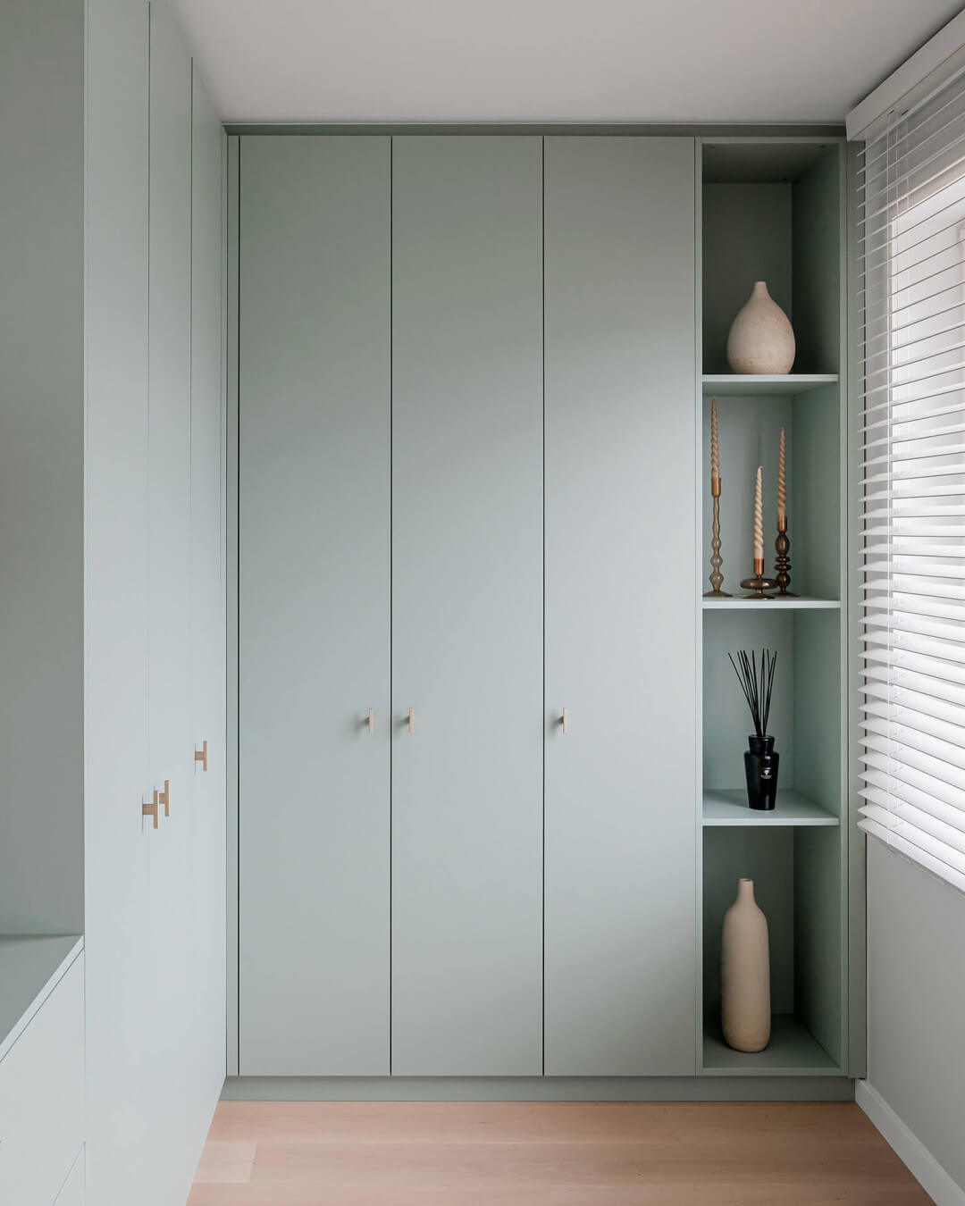 Bespoke cupboard in entrance hall in Industrial Green colour with brass handles