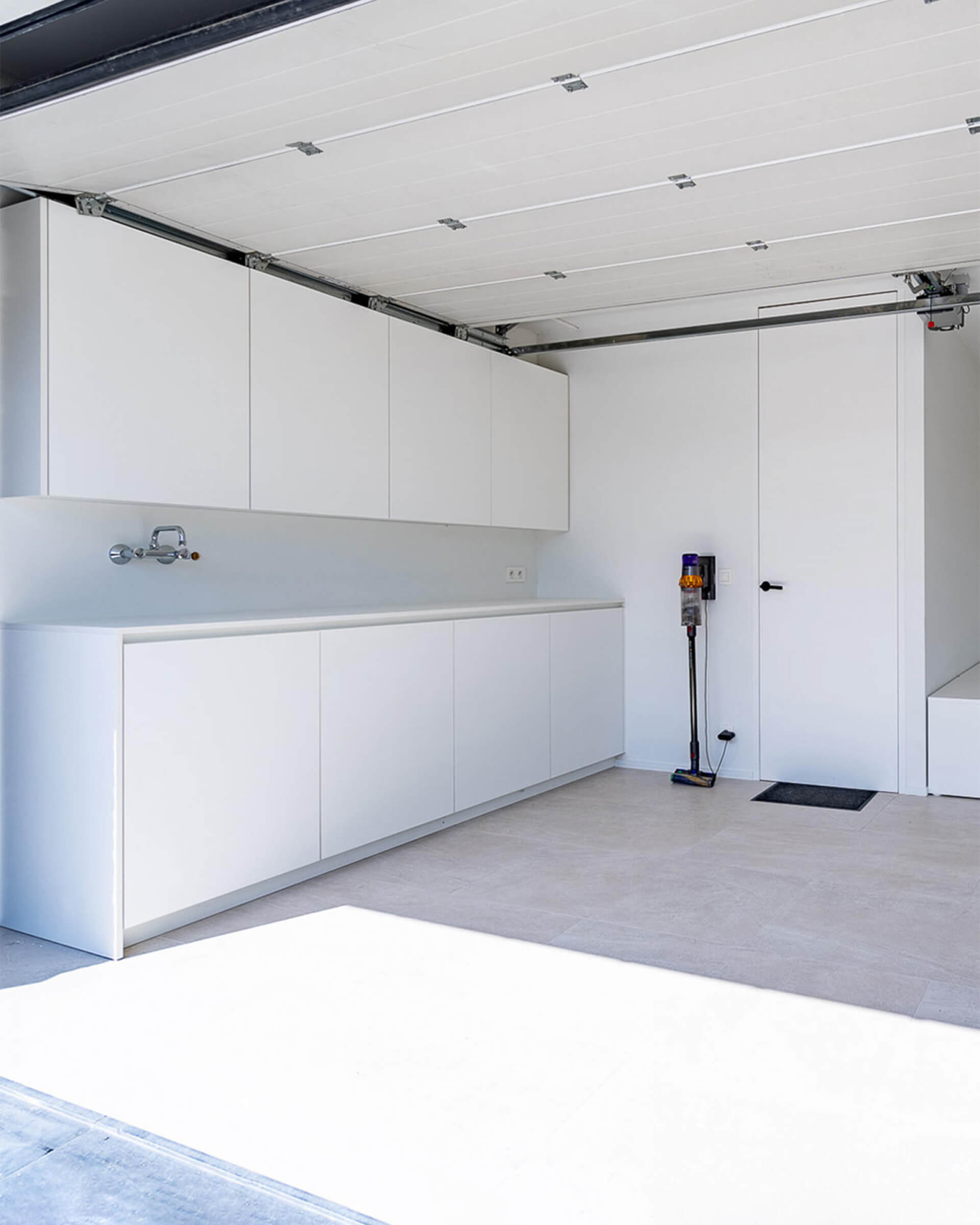 Custom wall-mounted cabinet in a garage, in the color Front White