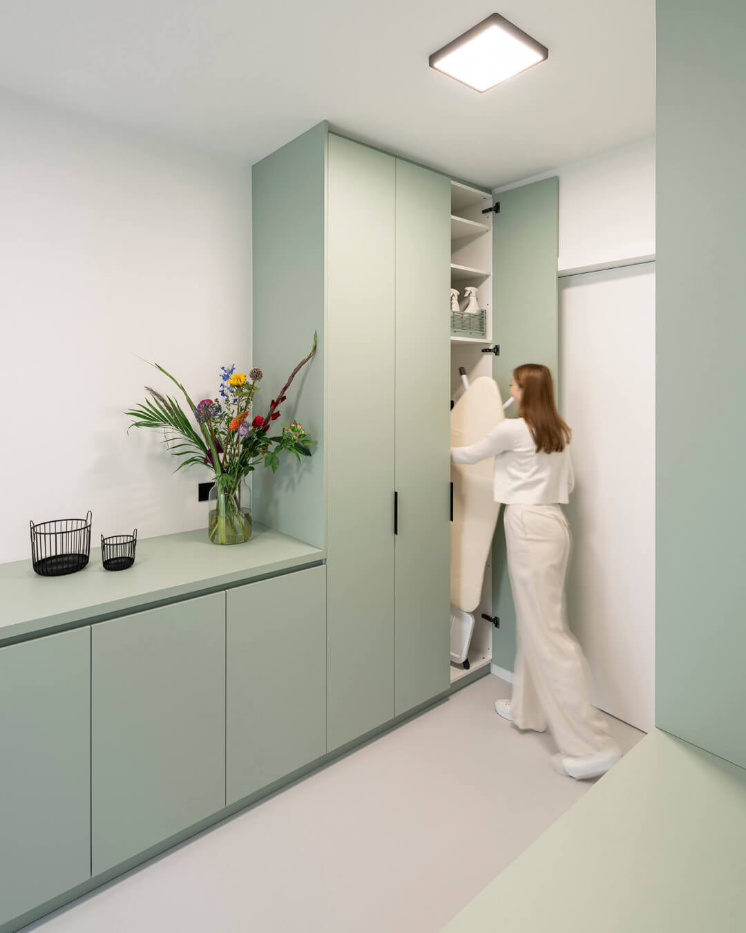 Storage cupboard for your ironing board in the laundry room