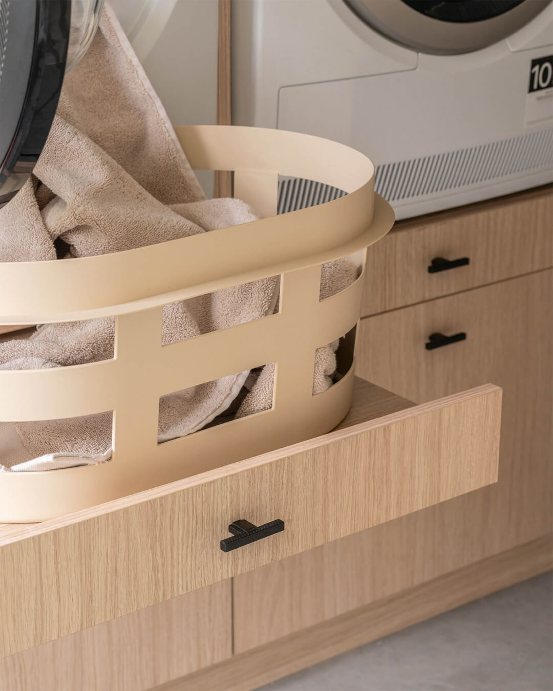 Pull-out shelf in a custom laundry cabinet in the color Atlas Oak