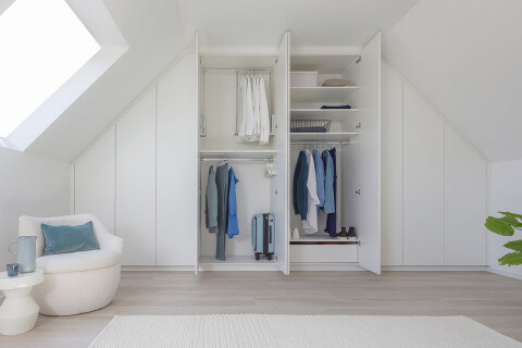 Bespoke white dressing room under a pitched roof from Maatkasten Online