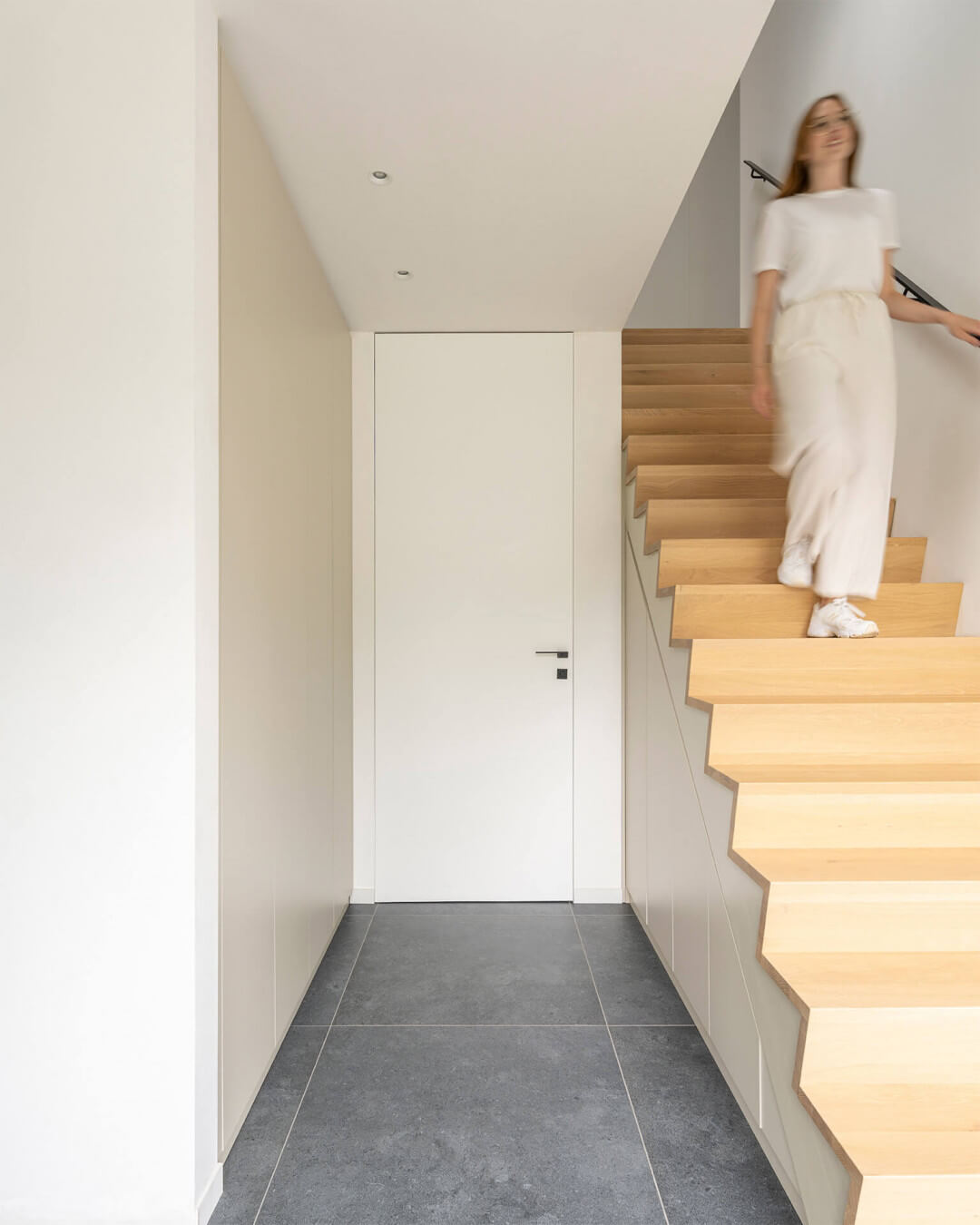 Custom hallway cabinet in the color Turtle Grey, next to an oak staircase