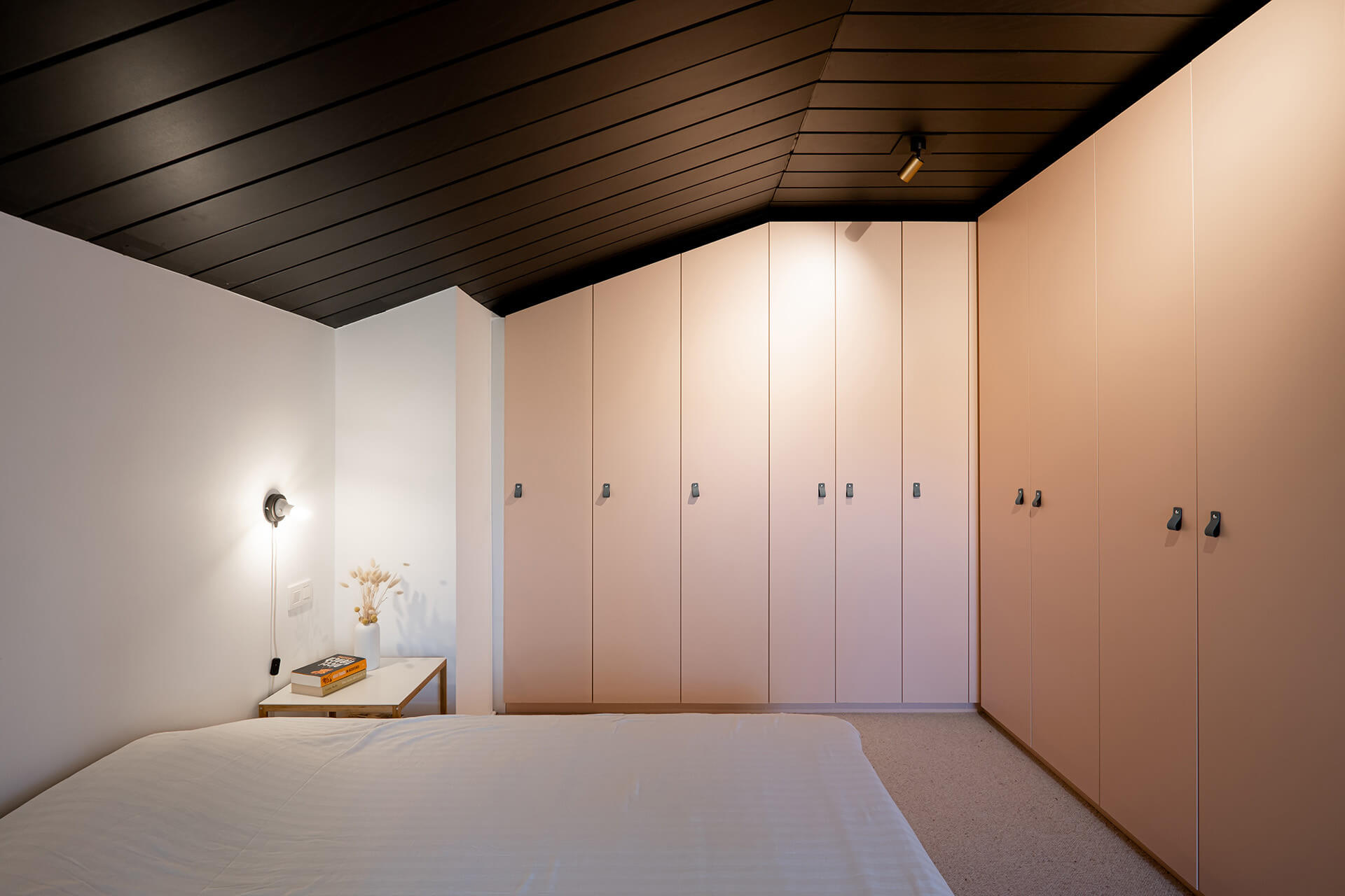l-shaped wardrobe in pastel pink integrated in the bedroom by maatkasten online