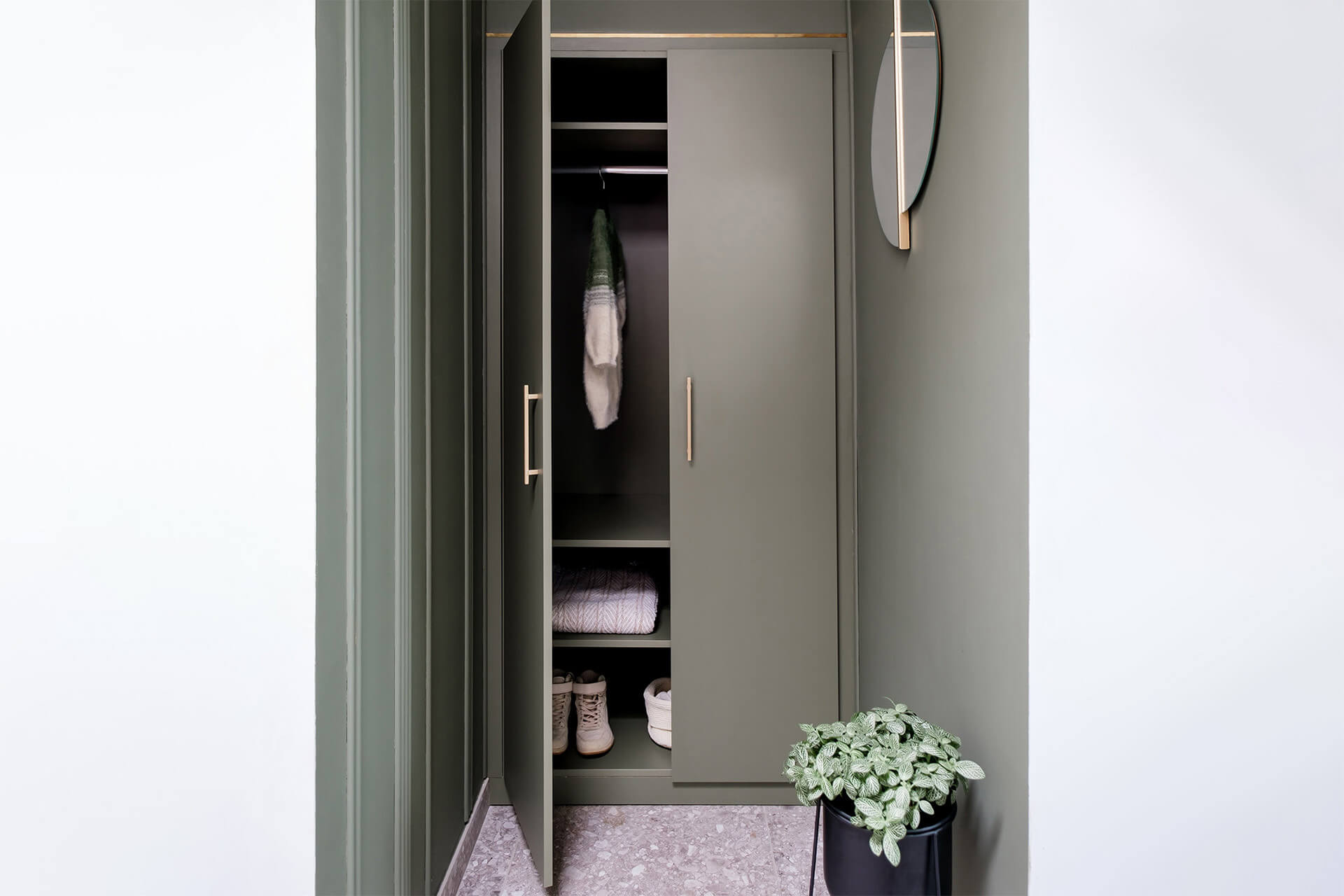 Custom-made green cupboard in the entrance hall with brass handles from maatkastenonline