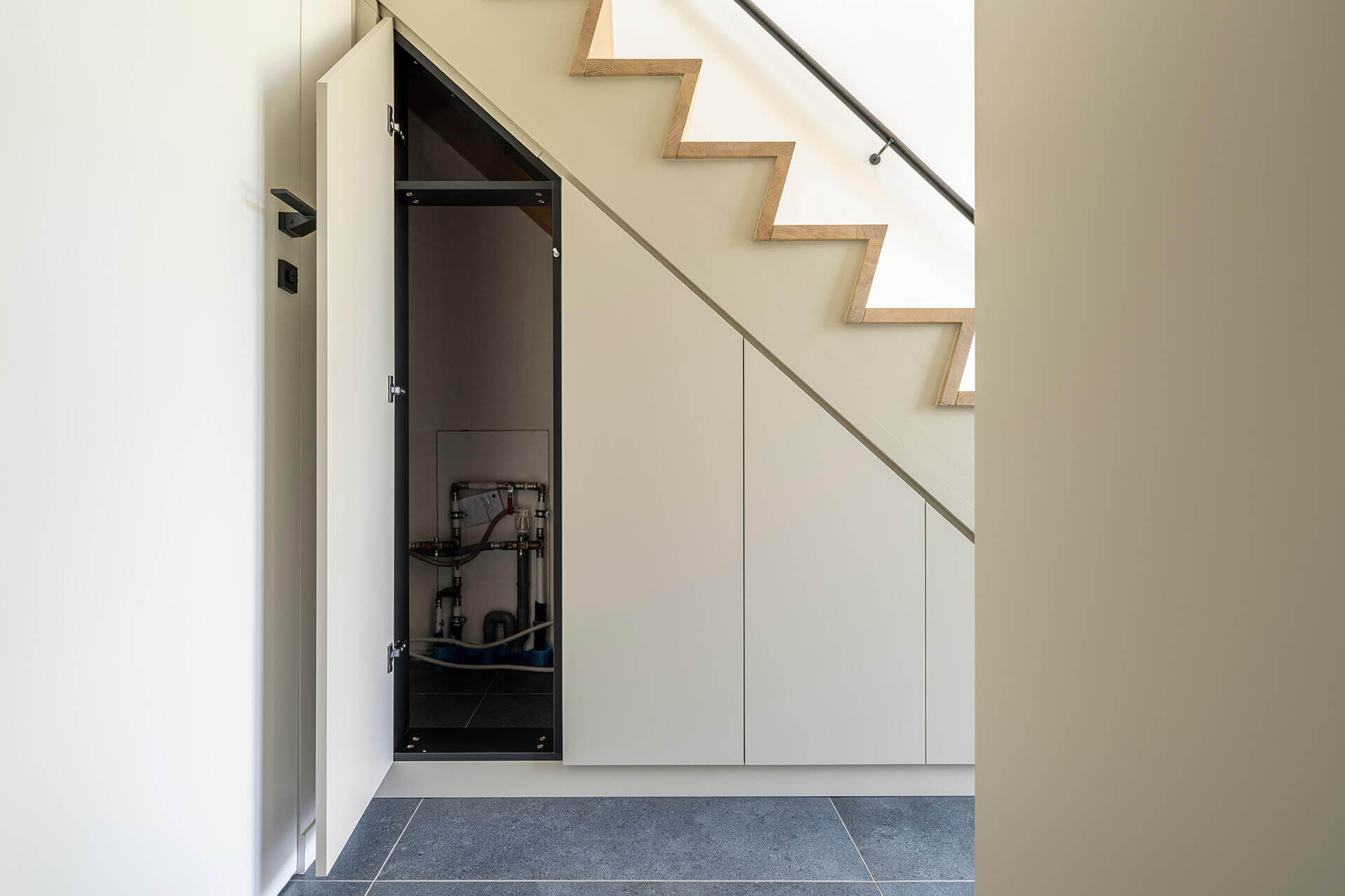 Custom staircase cabinet with space for utilities