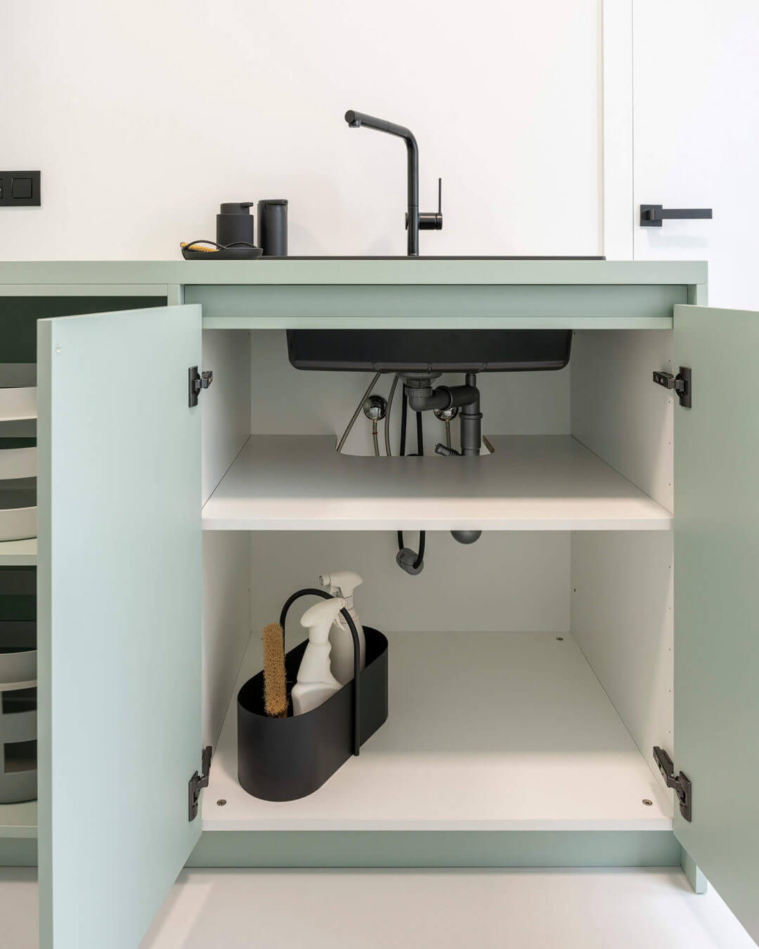 Black sink in a custom green cabinet 